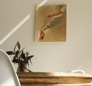 A serene minimalist room featuring a painting, wooden table, and potted plant.